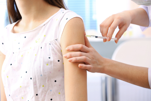  A woman with a bare arm getting a vaccine administered